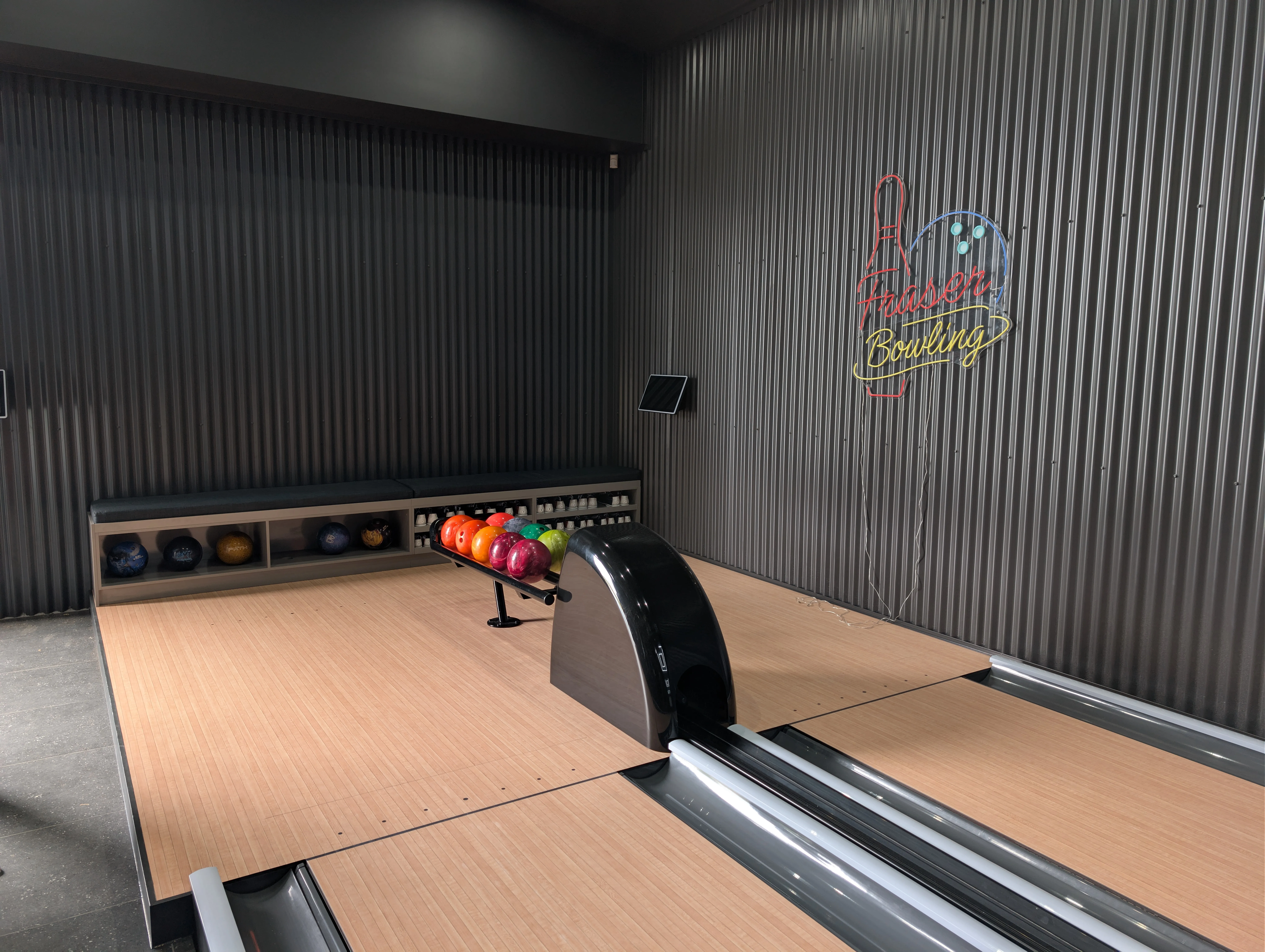 Completed private bowling shed showing the ball return, custom sign and approach area