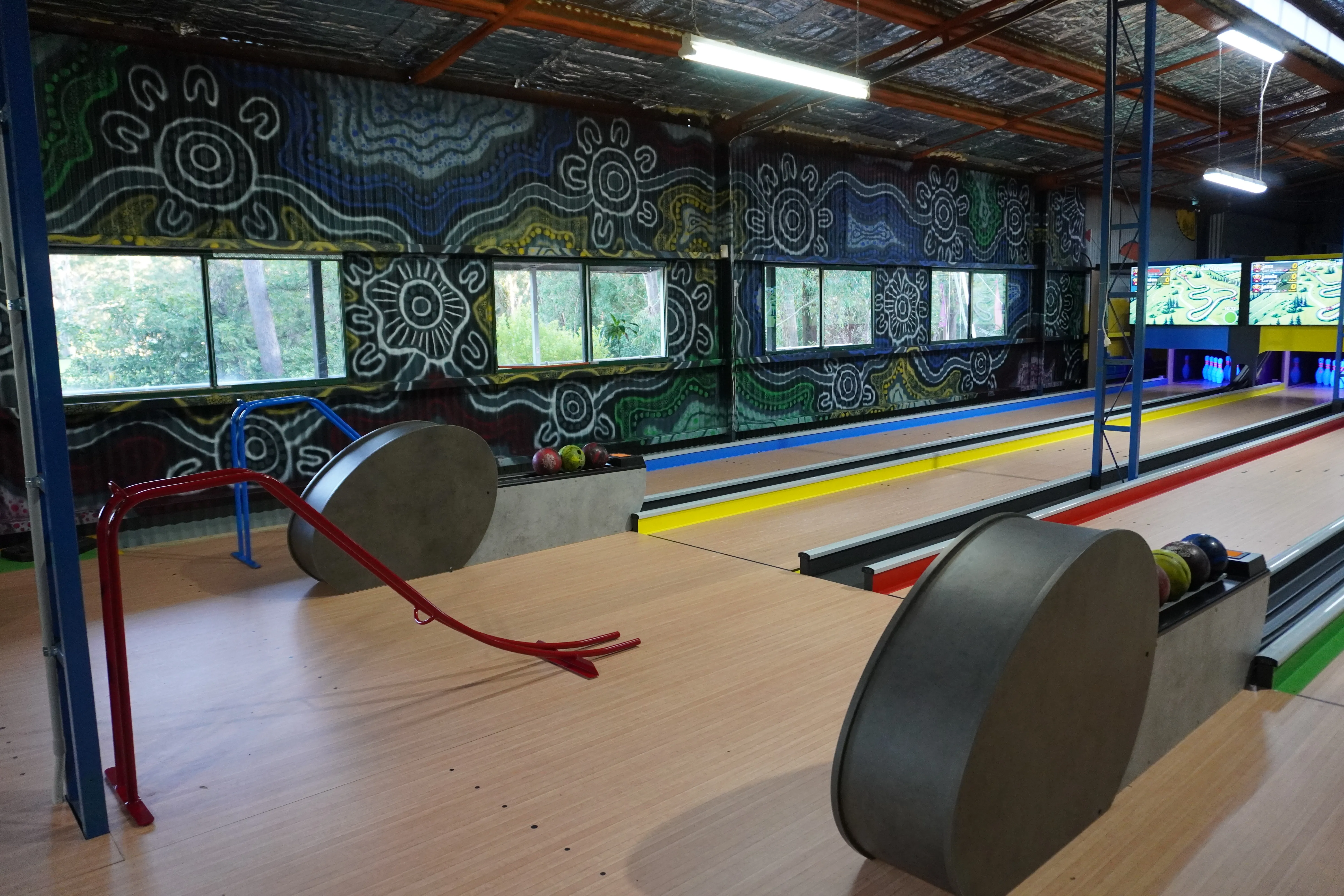 The bowling lanes at Toboggan Hill Park showing the approach area and themed mural backdrop